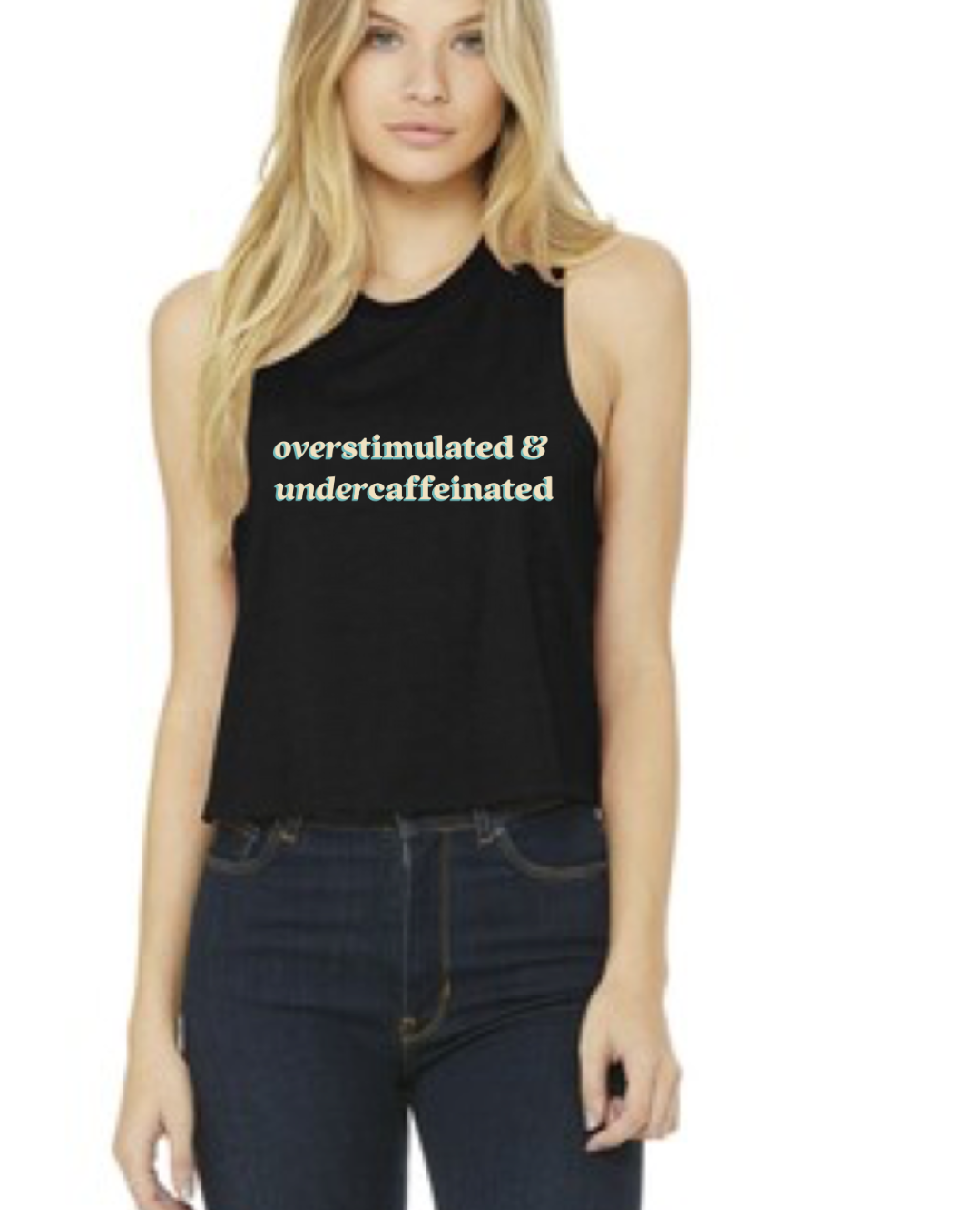 Woman wearing a black sleeveless shirt with white text 'overstimulated & undercaffeinated'