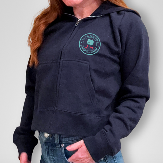 Person wearing a navy blue hoodie with a logo on a plain background